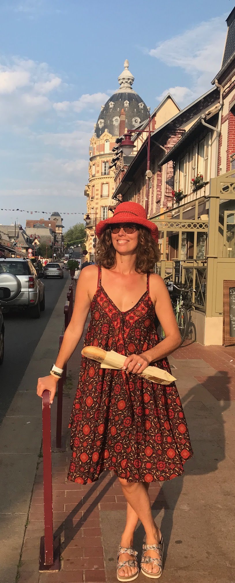Karine — NYC-based native French tutor for children, walking a French village street with a baguette